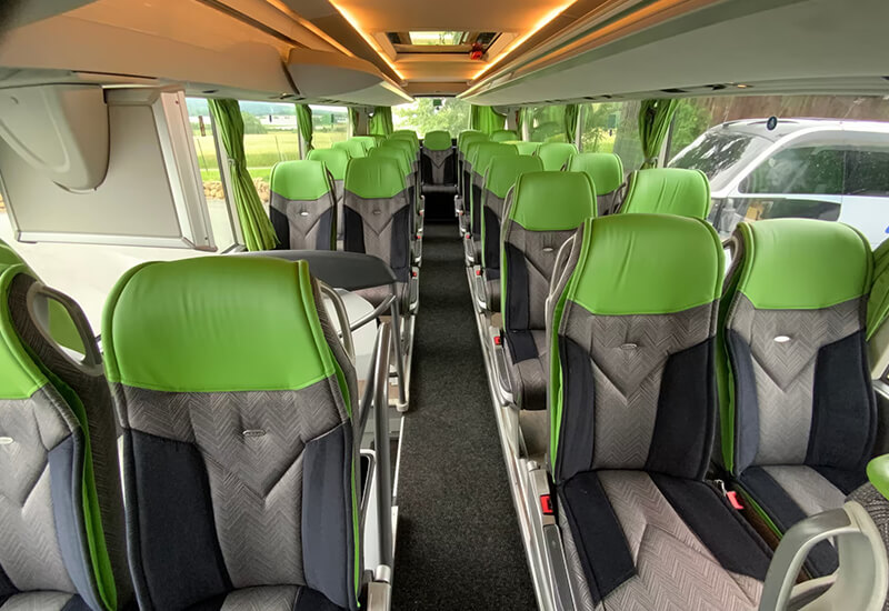 Green-and-grey seats along the aisle of a Setra double-deck coach